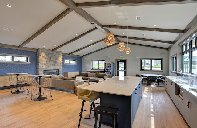 4802 N 187th Ave, Elkhorn, NE 68022 - kitchen with light wood-style floors, a fireplace, a center island, recessed lighting, and pendant lighting