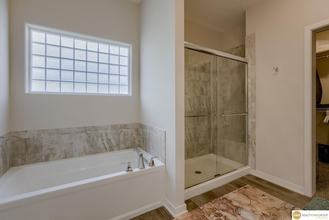 12618 Glenn St, Omaha, NE 68138 - bathroom with a bath, a walk in closet, wood finished floors, and a stall shower
