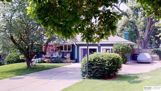 7923 Harney St, Omaha, NE 68114 - view of property hidden behind natural elements with a chimney, driveway, and a garage