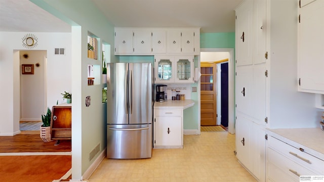 7923 Harney St, Omaha, NE 68114 - kitchen featuring freestanding refrigerator, light countertops, white cabinets, and light flooring