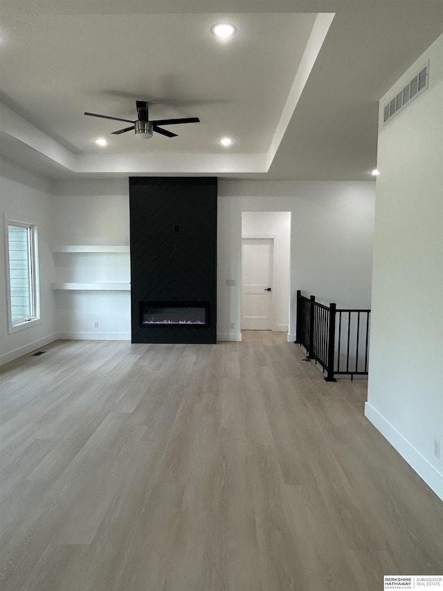 19756 Briar St, Gretna, NE 68028 - unfurnished living room featuring a tray ceiling, wood finished floors, a ceiling fan, recessed lighting, and built in shelves