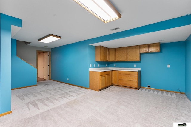 9521 N 140th St, Waverly, NE 68462 - kitchen featuring brown cabinets, light colored carpet, light countertops, and open floor plan