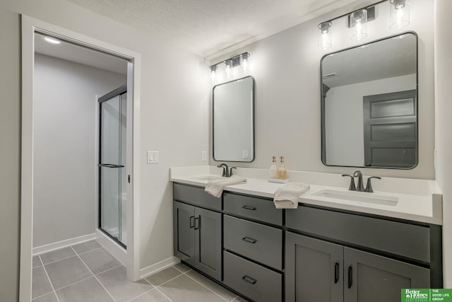 10110 Laramie St, Papillion, NE 68046 - bathroom featuring double vanity, a shower stall, tile patterned flooring, and a textured ceiling