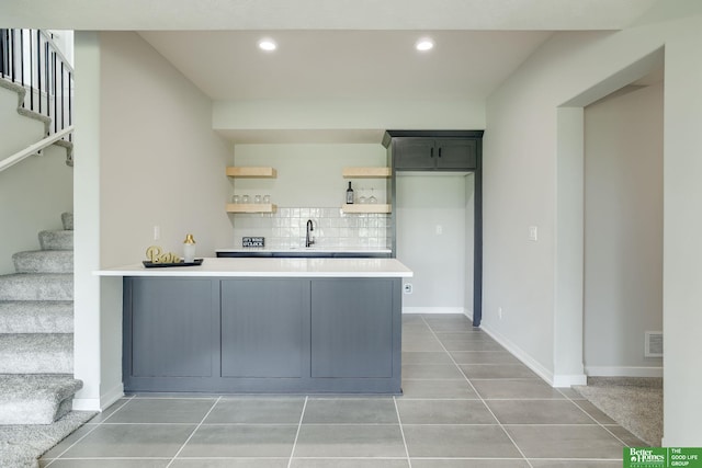 10110 Laramie St, Papillion, NE 68046 - kitchen featuring a peninsula, open shelves, light countertops, decorative backsplash, and light tile patterned floors
