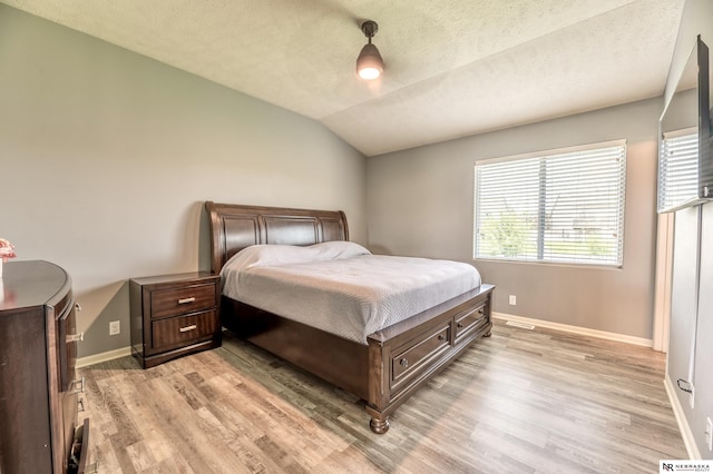 13913 Springview Dr, Papillion, NE 68133 - bedroom featuring light wood finished floors, lofted ceiling, and a textured ceiling
