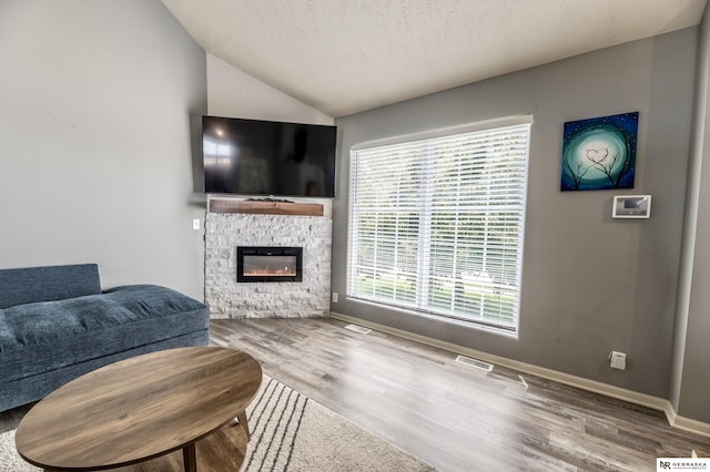 13913 Springview Dr, Papillion, NE 68133 - living area with wood finished floors, vaulted ceiling, a fireplace, and a textured ceiling