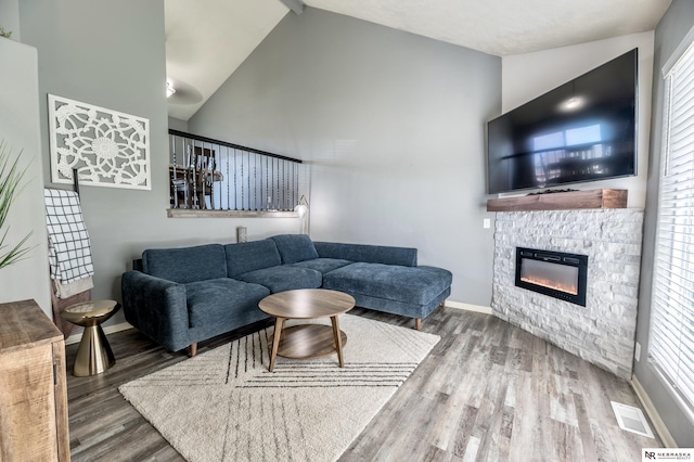 13913 Springview Dr, Papillion, NE 68133 - living room with high vaulted ceiling, wood finished floors, a glass covered fireplace, healthy amount of natural light, and beam ceiling
