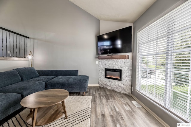 13913 Springview Dr, Papillion, NE 68133 - living area featuring vaulted ceiling, wood finished floors, and a stone fireplace