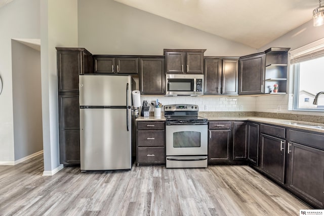 13913 Springview Dr, Papillion, NE 68133 - kitchen with stainless steel appliances, vaulted ceiling, dark brown cabinets, and backsplash