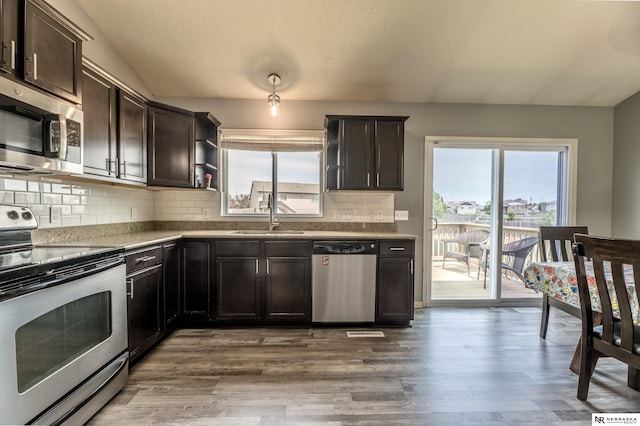 13913 Springview Dr, Papillion, NE 68133 - kitchen with stainless steel appliances, dark brown cabinetry, decorative backsplash, wood finished floors, and plenty of natural light