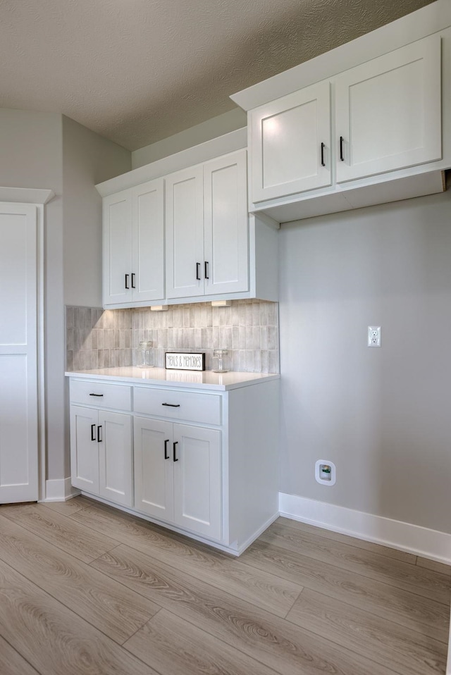 5620 N 212th St, Elkhorn, NE 68022 - kitchen with light wood finished floors, light countertops, white cabinetry, and tasteful backsplash