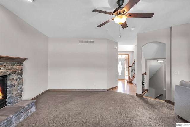 10149 Edward St, La Vista, NE 68128 - unfurnished living room featuring carpet flooring, ceiling fan, a stone fireplace, and stairs