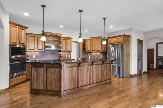 10149 Edward St, La Vista, NE 68128 - kitchen with stainless steel appliances, open shelves, under cabinet range hood, a center island with sink, and brown cabinetry