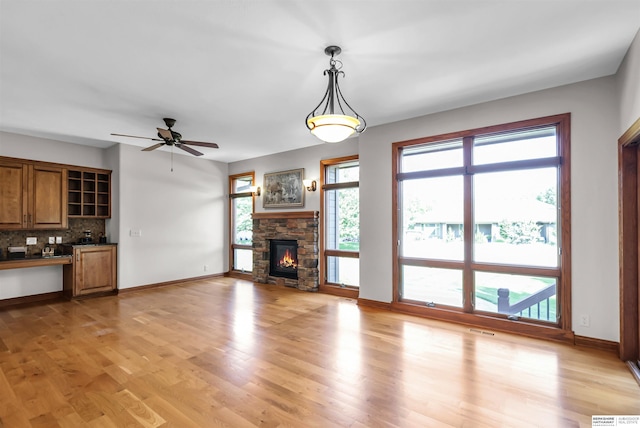 10149 Edward St, La Vista, NE 68128 - unfurnished living room featuring light wood-type flooring, a fireplace, and a ceiling fan
