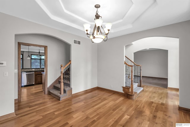 10149 Edward St, La Vista, NE 68128 - empty room featuring stairs, arched walkways, a chandelier, and a raised ceiling
