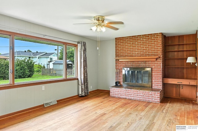 3335 N 207th Ter, Elkhorn, NE 68022 - unfurnished living room featuring hardwood / wood-style flooring, a ceiling fan, and a brick fireplace