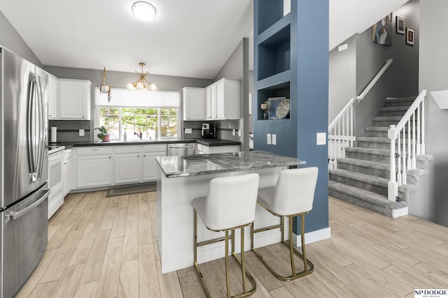 18667 R St, Omaha, NE 68135 - kitchen with appliances with stainless steel finishes, light wood-style floors, backsplash, a kitchen bar, and lofted ceiling