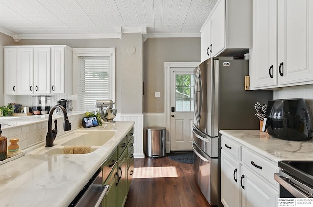 1139 E 5th St, Fremont, NE 68025 - kitchen with crown molding, dark wood-type flooring, a wainscoted wall, white cabinets, and appliances with stainless steel finishes