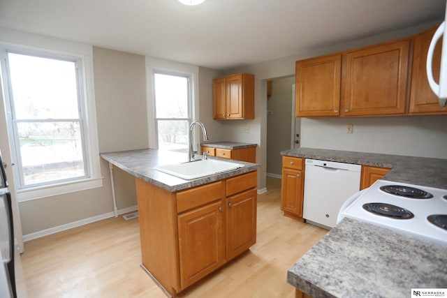 809 S 36th St, Omaha, NE 68105 - kitchen with dishwasher, light wood-type flooring, brown cabinetry, and a center island with sink