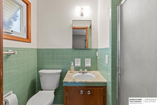 8832 Spaulding Cir, Omaha, NE 68134 - full bathroom with vanity, tile walls, a shower stall, and a wainscoted wall