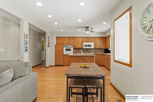 8832 Spaulding Cir, Omaha, NE 68134 - kitchen with white appliances, open floor plan, recessed lighting, a center island, and tasteful backsplash