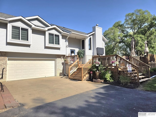 1002 Oak Ct, Plattsmouth, NE 68048 - bi-level home featuring brick siding, a garage, stairs, and concrete driveway