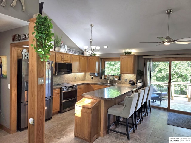 1002 Oak Ct, Plattsmouth, NE 68048 - kitchen with stainless steel appliances, a peninsula, tasteful backsplash, plenty of natural light, and vaulted ceiling