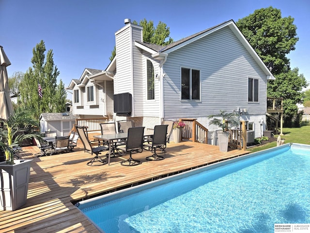 1002 Oak Ct, Plattsmouth, NE 68048 - outdoor pool with outdoor dining area, a deck, and a storage shed