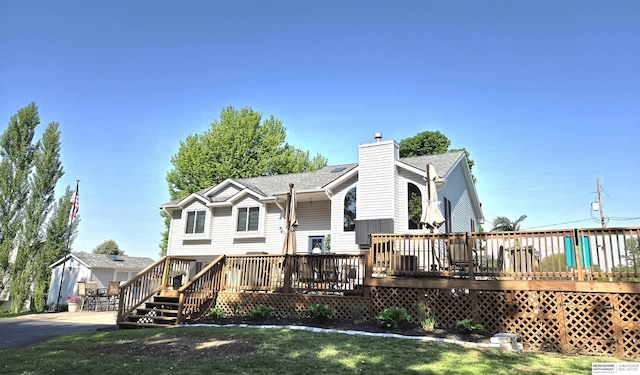 1002 Oak Ct, Plattsmouth, NE 68048 - rear view of property with a chimney, a deck, roof with shingles, and a yard