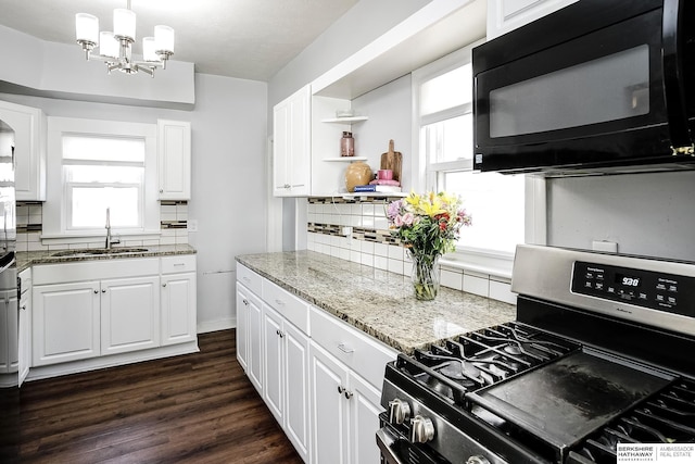 4814 Poppleton Ave, Omaha, NE 68106 - kitchen featuring gas range, black microwave, tasteful backsplash, a chandelier, and white cabinets