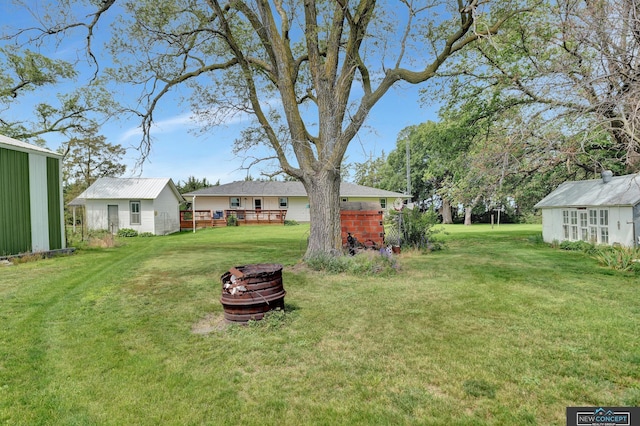 19354 SW 117th Rd, Dewitt, NE 68341 - view of green lawn with an outbuilding, a deck, and an outdoor fire pit