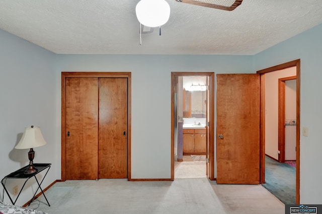 19354 SW 117th Rd, Dewitt, NE 68341 - unfurnished bedroom with light carpet, a closet, a textured ceiling, ensuite bathroom, and a ceiling fan