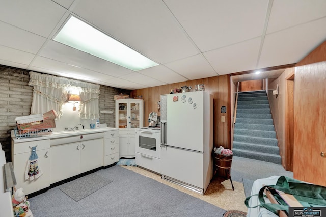 19354 SW 117th Rd, Dewitt, NE 68341 - kitchen with white appliances, light countertops, a paneled ceiling, white cabinetry, and wooden walls