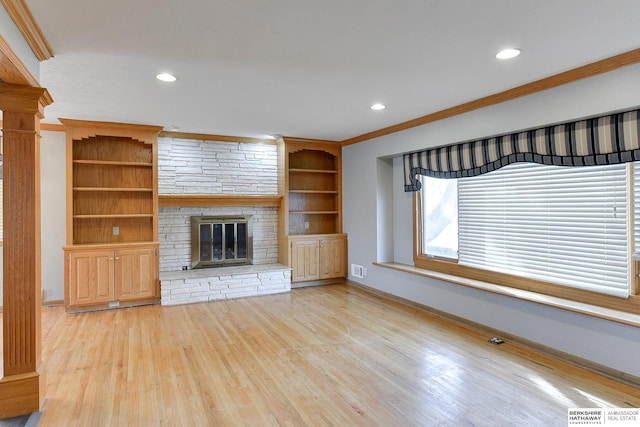 12102 Westover Rd, Omaha, NE 68154 - unfurnished living room with ornamental molding, light wood-style floors, recessed lighting, a stone fireplace, and built in features