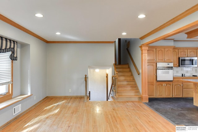 12102 Westover Rd, Omaha, NE 68154 - kitchen with white oven, stainless steel microwave, ornamental molding, backsplash, and recessed lighting