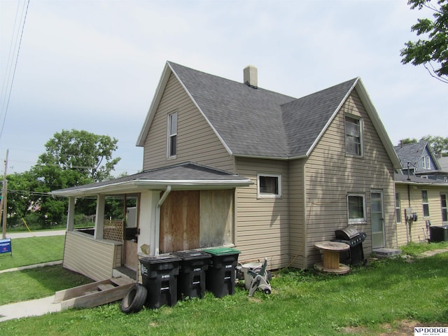 2711 Shirley St, Omaha, NE 68105 - view of side of property featuring a shingled roof, a lawn, and a chimney