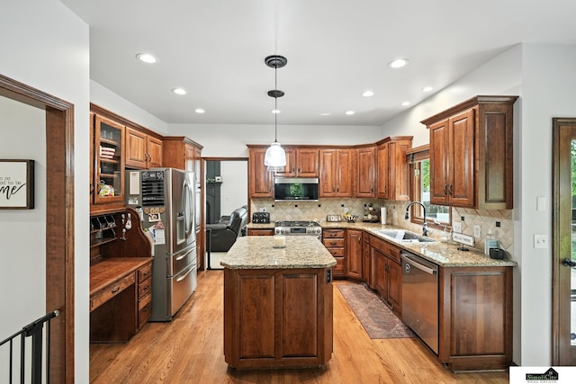 5807 S 167th Ave, Omaha, NE 68135 - kitchen featuring appliances with stainless steel finishes, a kitchen island, light stone counters, light wood-type flooring, and recessed lighting