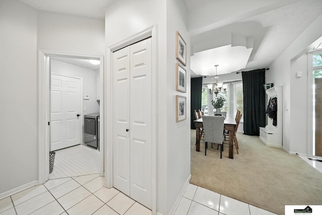 5807 S 167th Ave, Omaha, NE 68135 - hallway featuring light carpet, a chandelier, and light tile patterned floors