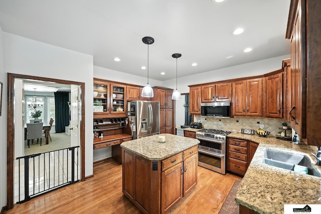 5807 S 167th Ave, Omaha, NE 68135 - kitchen featuring stainless steel appliances, light wood-type flooring, a center island, light stone counters, and backsplash