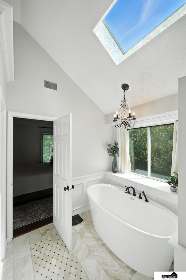 5807 S 167th Ave, Omaha, NE 68135 - full bath featuring a freestanding tub, a skylight, a chandelier, a wainscoted wall, and high vaulted ceiling