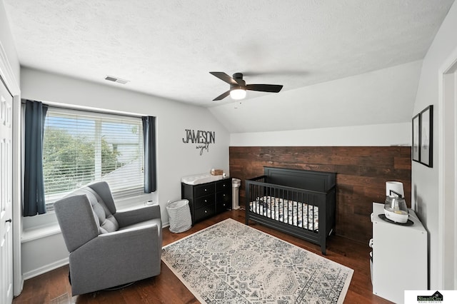 5807 S 167th Ave, Omaha, NE 68135 - bedroom featuring lofted ceiling, a textured ceiling, a crib, wood finished floors, and a ceiling fan