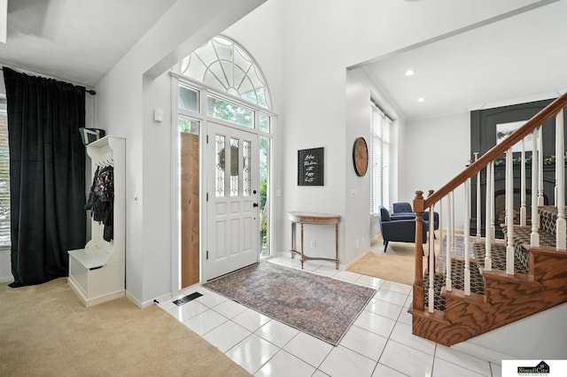 5807 S 167th Ave, Omaha, NE 68135 - foyer featuring carpet flooring, tile patterned floors, recessed lighting, stairs, and a high ceiling