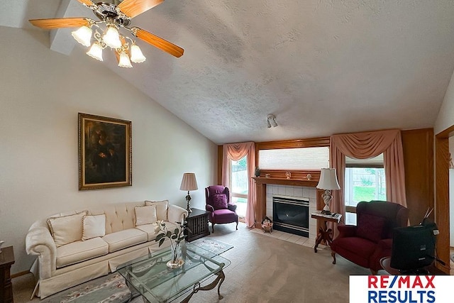 17315 M St, Omaha, NE 68135 - carpeted living area featuring plenty of natural light, a tiled fireplace, lofted ceiling, a ceiling fan, and a textured ceiling