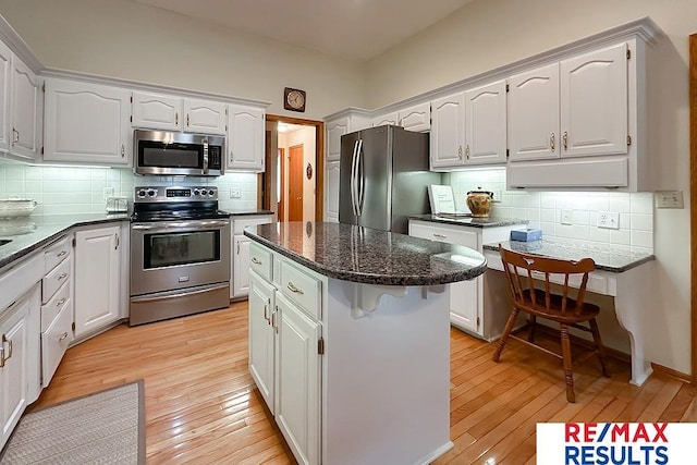 17315 M St, Omaha, NE 68135 - kitchen with stainless steel appliances, decorative backsplash, a center island, and light wood finished floors
