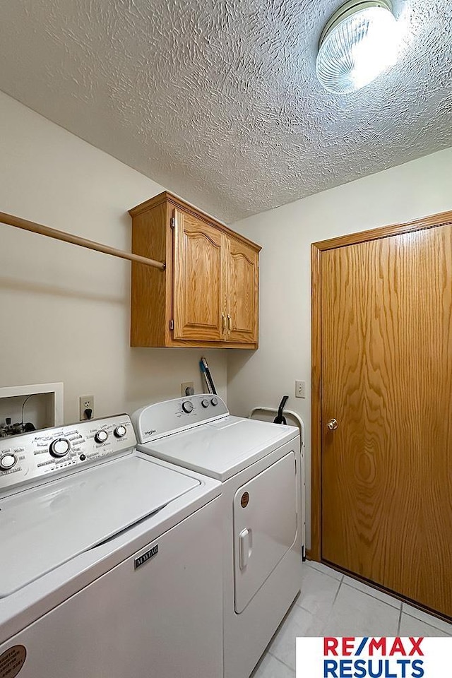 17315 M St, Omaha, NE 68135 - laundry room featuring cabinet space, washing machine and dryer, light tile patterned floors, and a textured ceiling