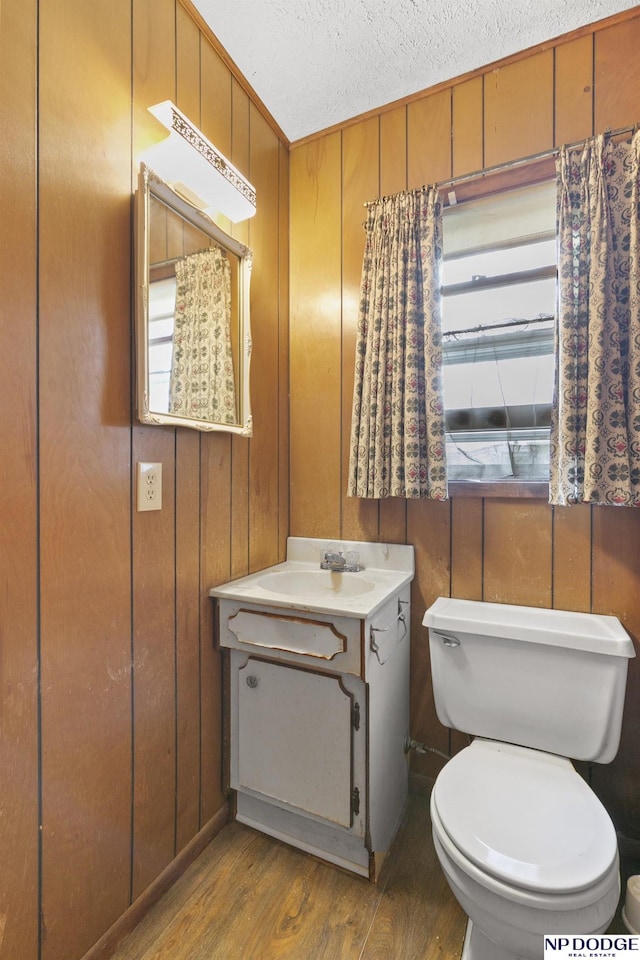 602 N 85th St, Omaha, NE 68114 - half bath featuring wood finished floors, vanity, a textured ceiling, and wood walls