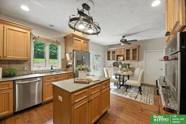454 N 61st St, Omaha, NE 68132 - kitchen featuring appliances with stainless steel finishes, ceiling fan, wood finished floors, backsplash, and light countertops