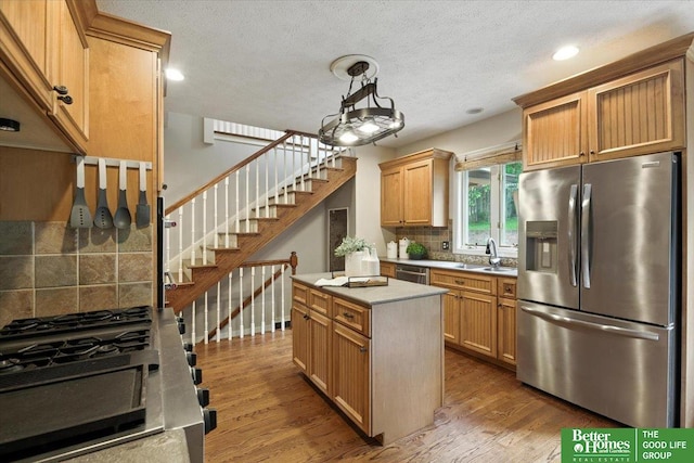 454 N 61st St, Omaha, NE 68132 - kitchen with appliances with stainless steel finishes, backsplash, wood finished floors, a center island, and light countertops