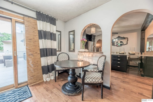 2105 S 164th Ave, Omaha, NE 68130 - dining space featuring wood finished floors, arched walkways, and a textured ceiling