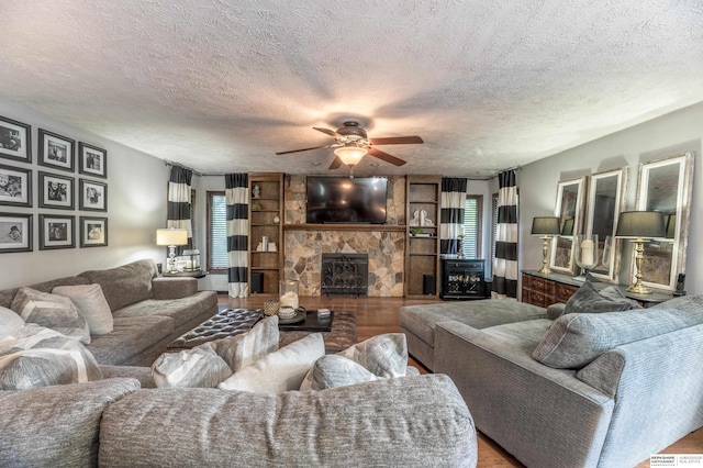 2105 S 164th Ave, Omaha, NE 68130 - living room with a ceiling fan, a stone fireplace, wood finished floors, and a textured ceiling